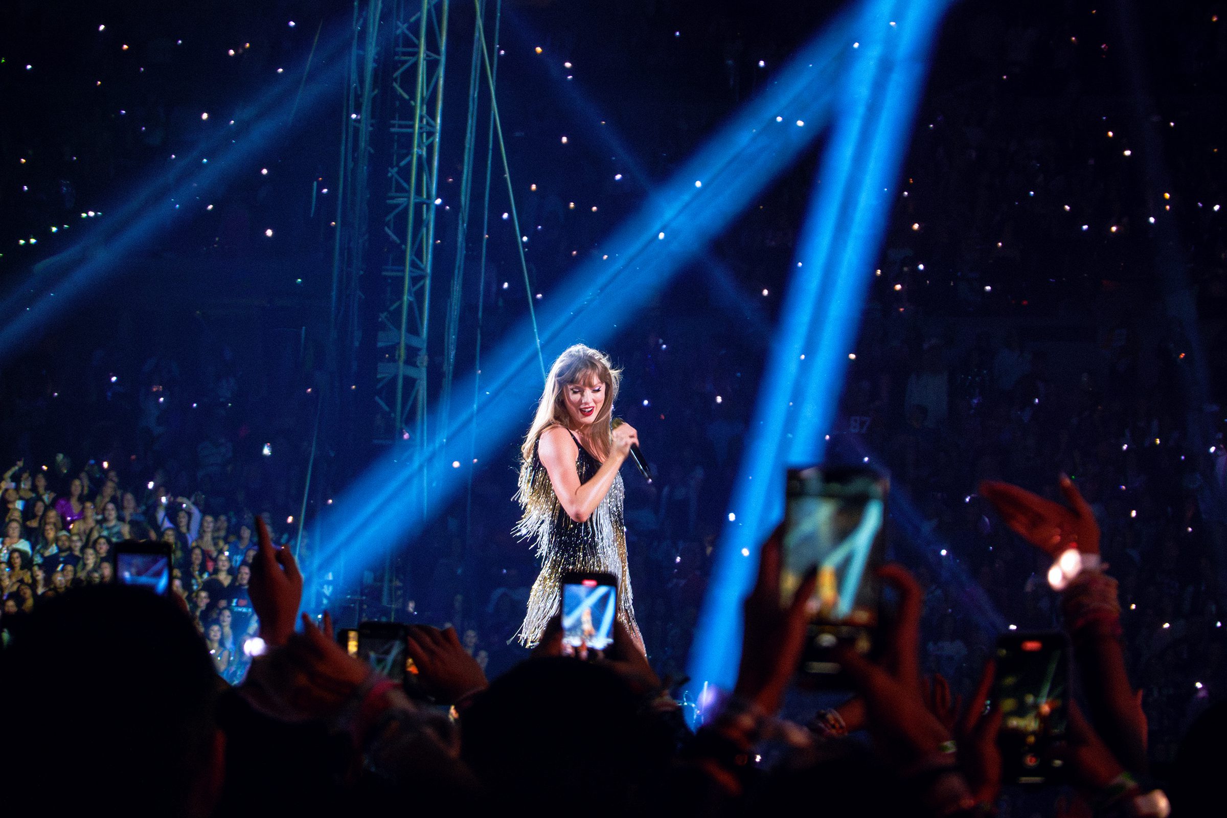 Taylor swift performs under blue lights at lucas oil stadium eras tour