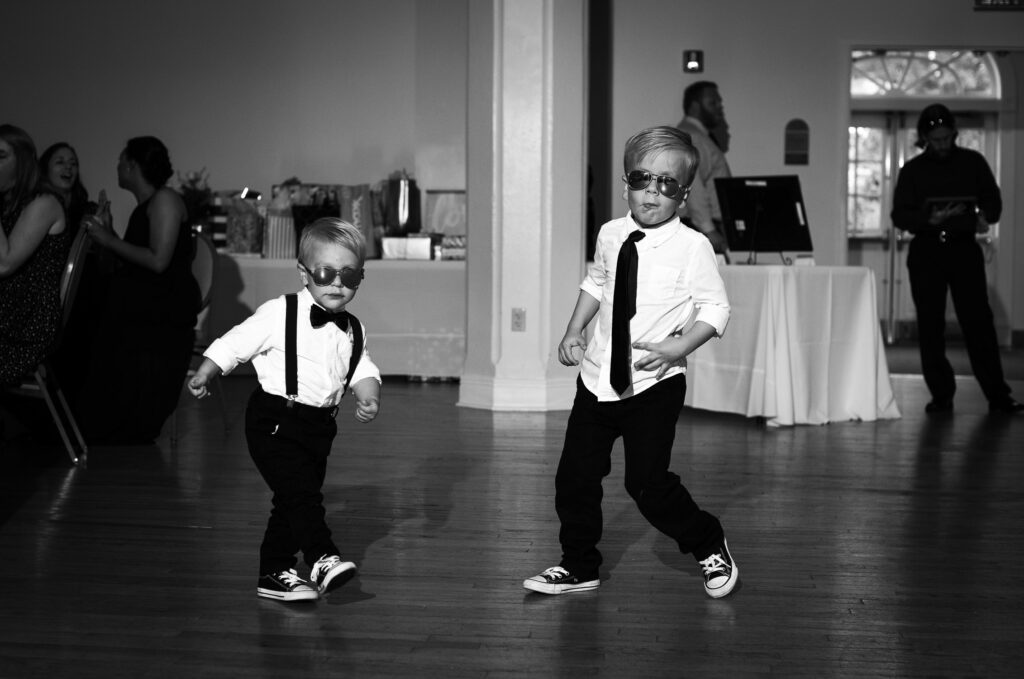 little boys dancing in suspenders and sunglass at wedding reception