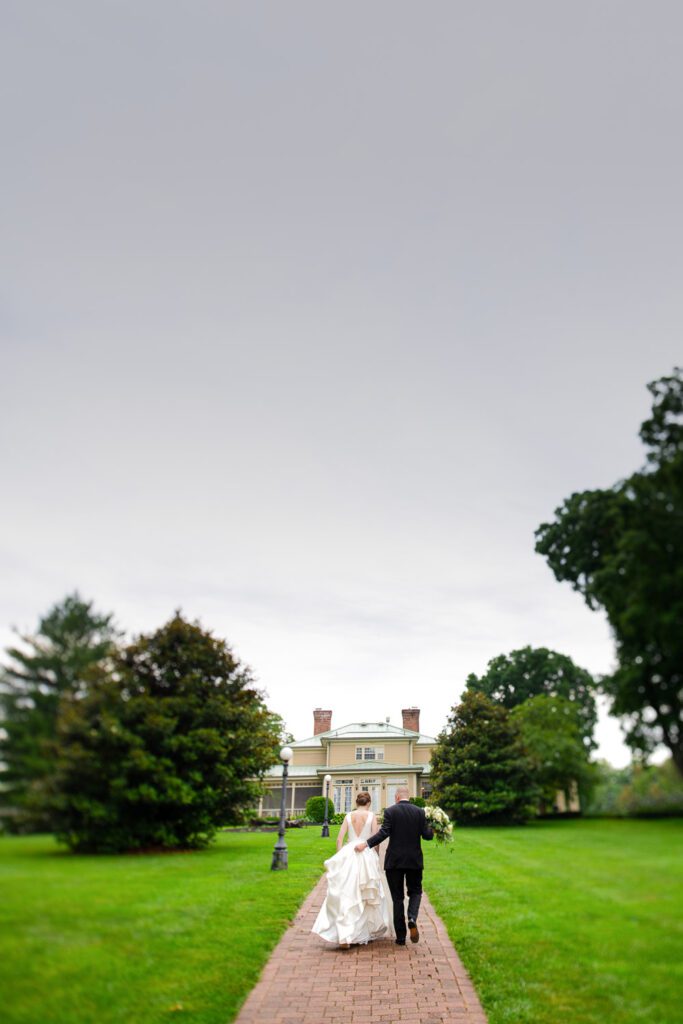 bride and groom running down pathway to house Washington, MO