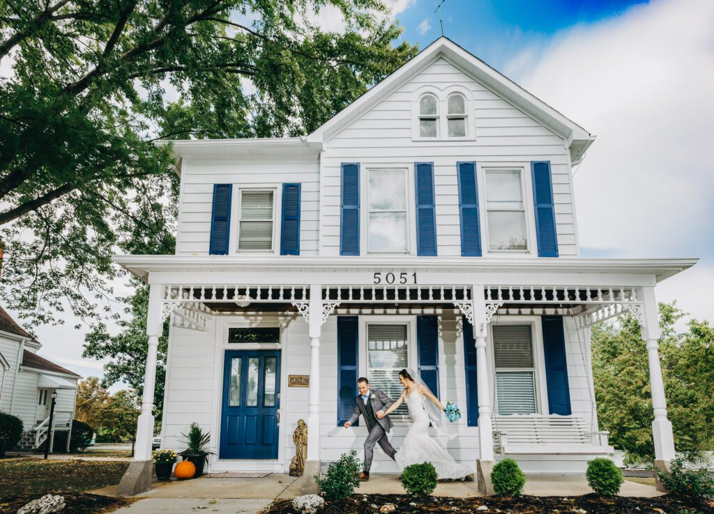 bride and groom running in front of charming house