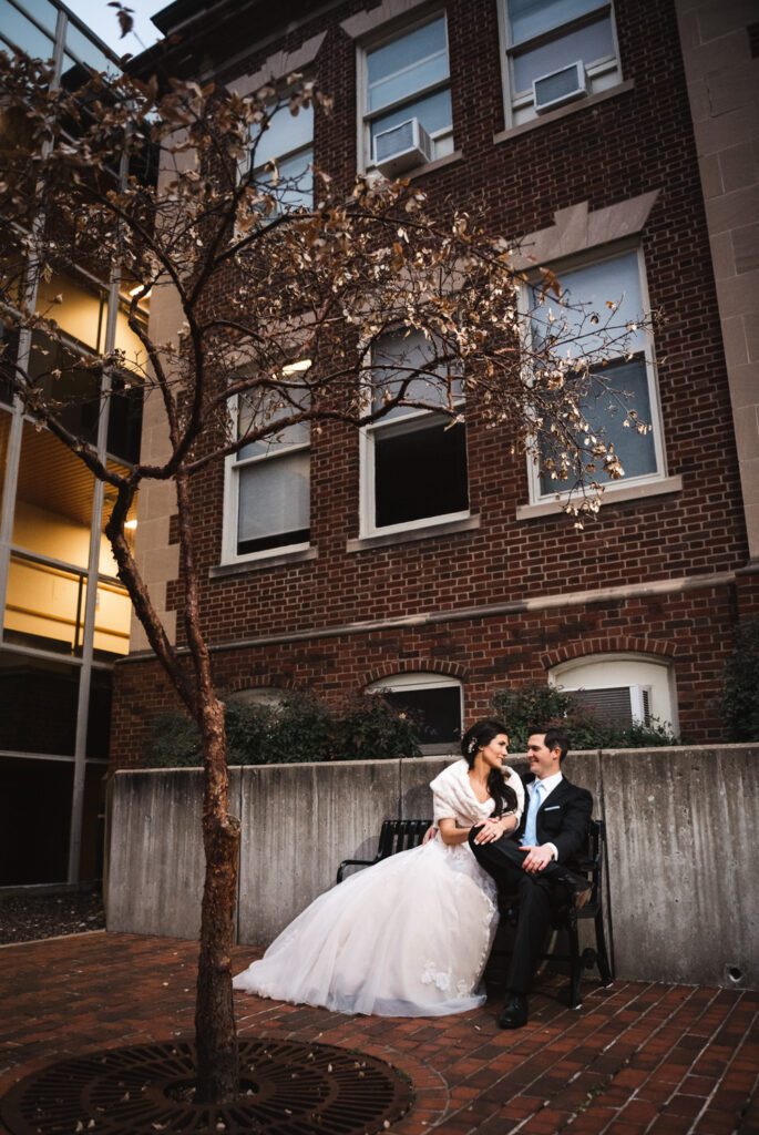 bride and groom sitting together near building