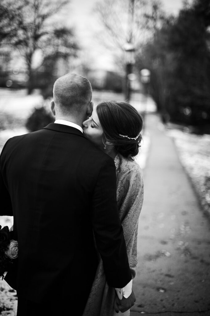 bride kissing groom on winter day