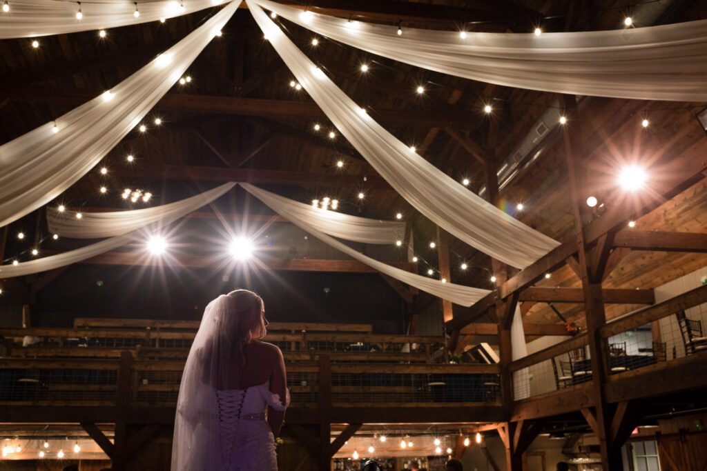 bride under strung lights at reception at The Barn III Goodfield, IL
