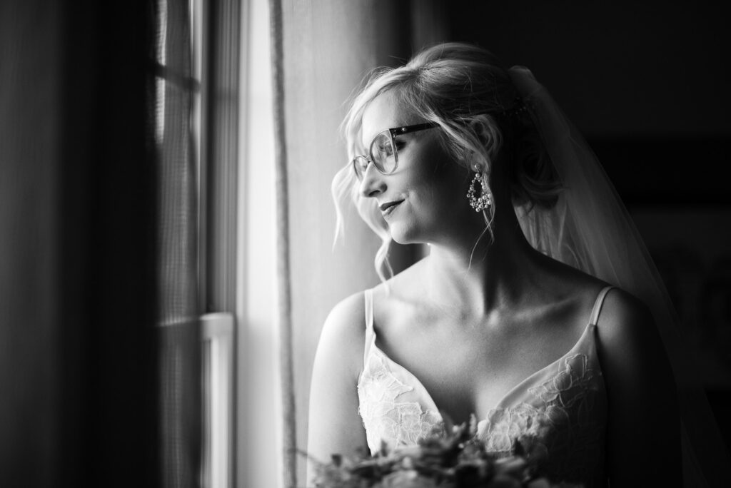 bride wearing glasses looking out window
