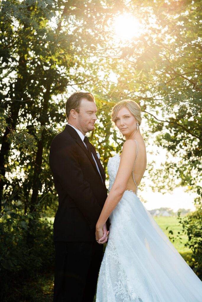 groom smiling at bride looking in to distance at sunset