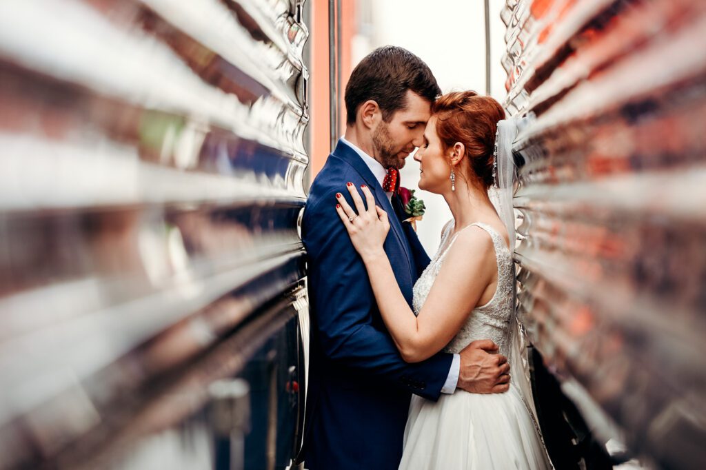 newlyweds snuggle up between two trains