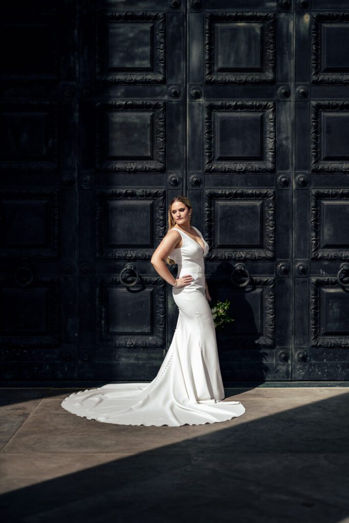 bride posing in front of black doors