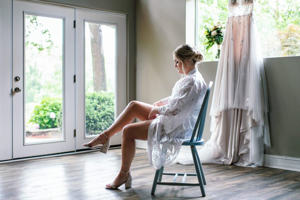 bride putting on garter in window