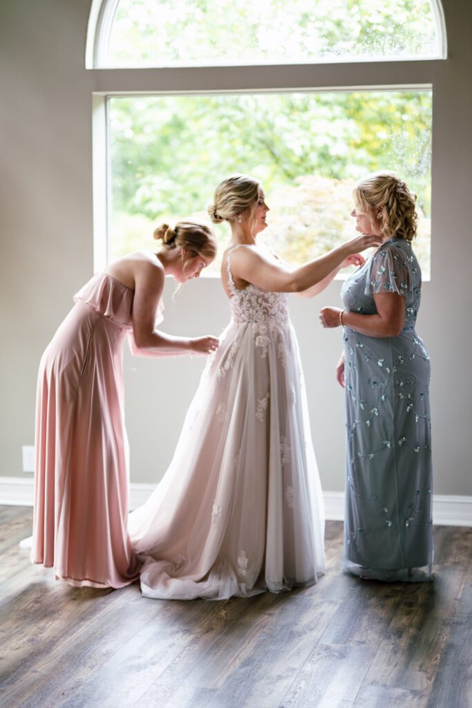 A bride getting into her gown with family members
