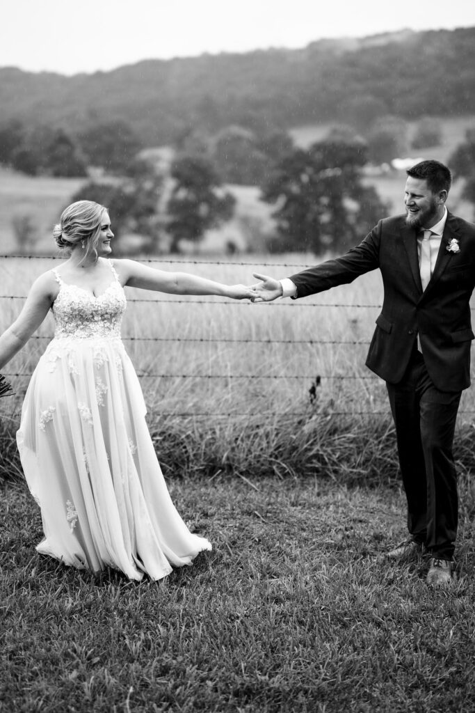 bride and groom dancing in field