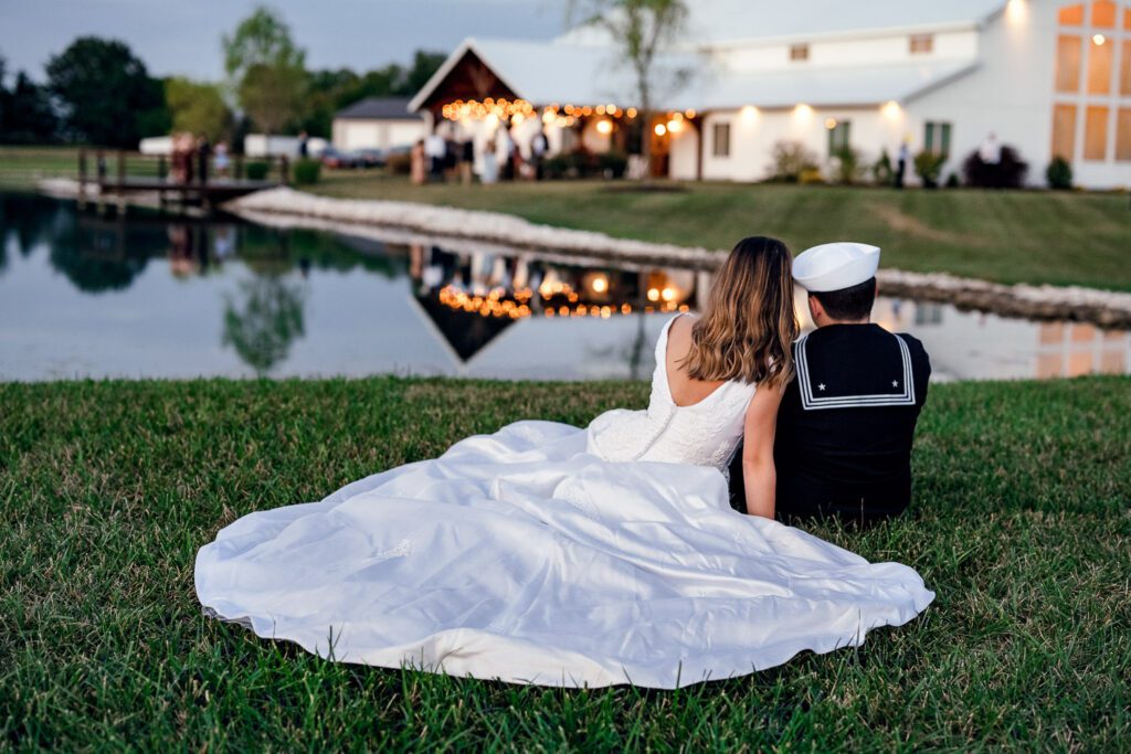 bride and groom in front of pond at venue