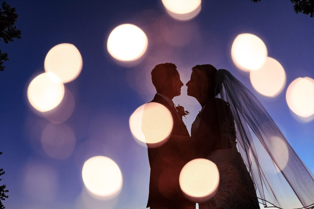 double exposure of lights over silhouette of bride and groom