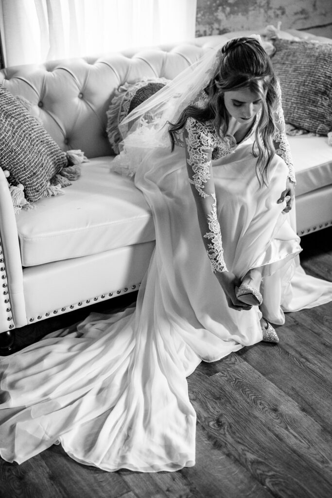 bride putting on shoes on a couch