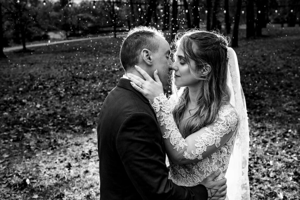 bride touching grooms face in the rain