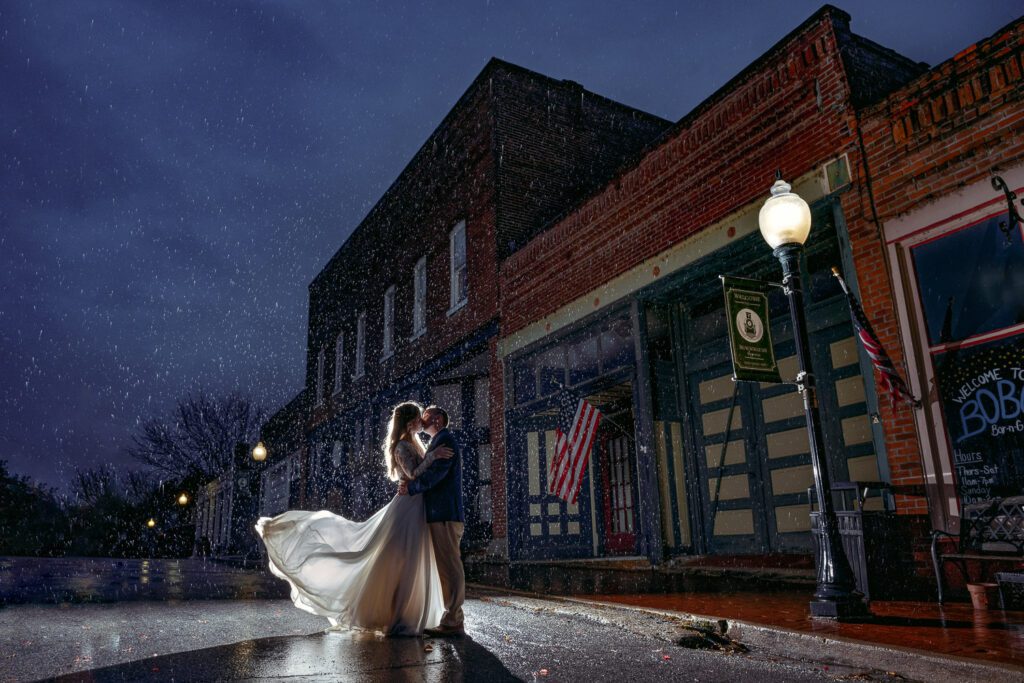 bride and groom in the rain outside of a hotel