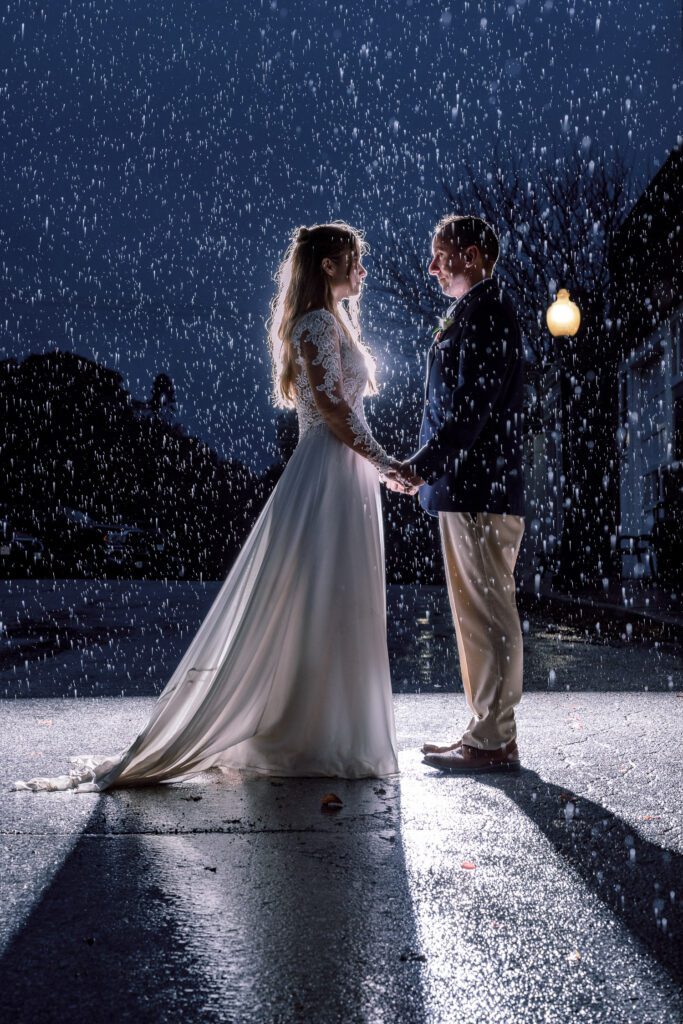 bride and groom holding hands in nighttime rain