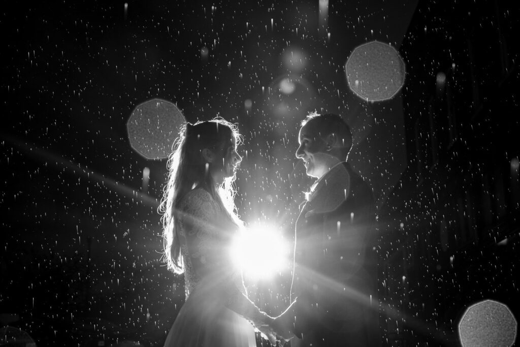 Black and white image of raindrops with bride and groom