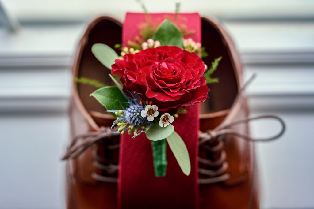 flowers and a tie on top of grooms shoes
