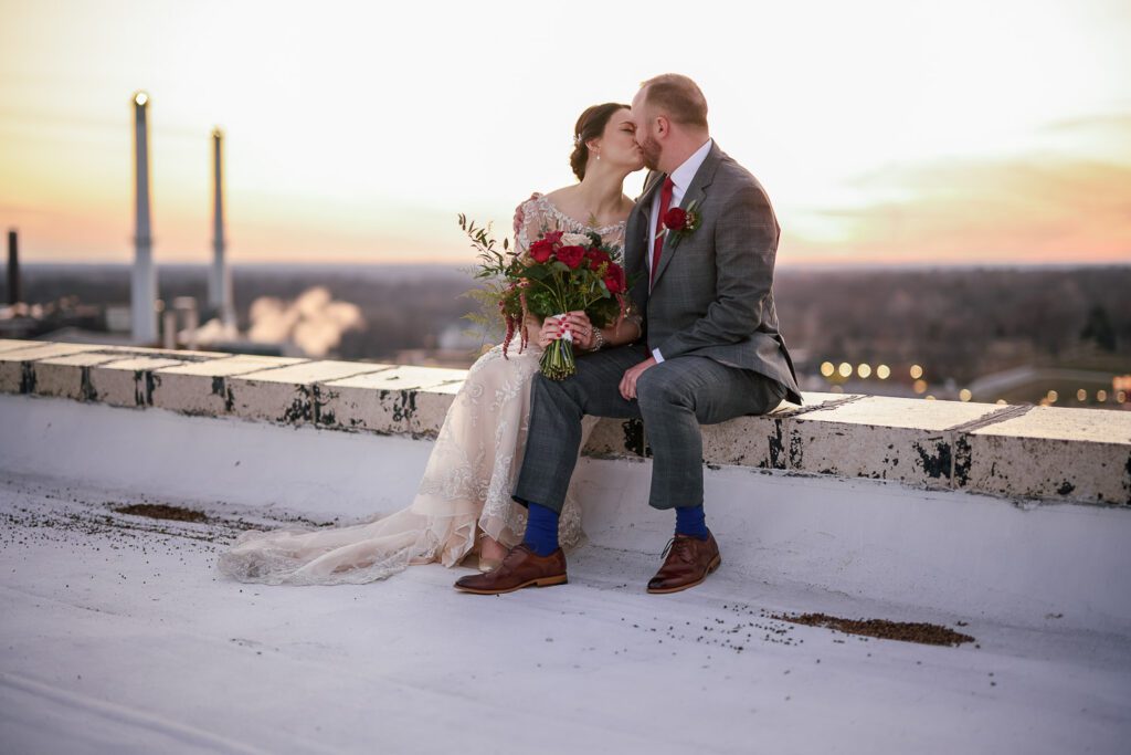 bride and groom kissing in front of smoke stacks