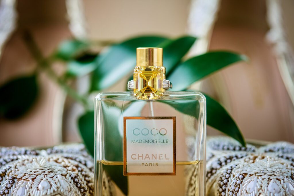 perfume bottle with wedding shoes and greenery