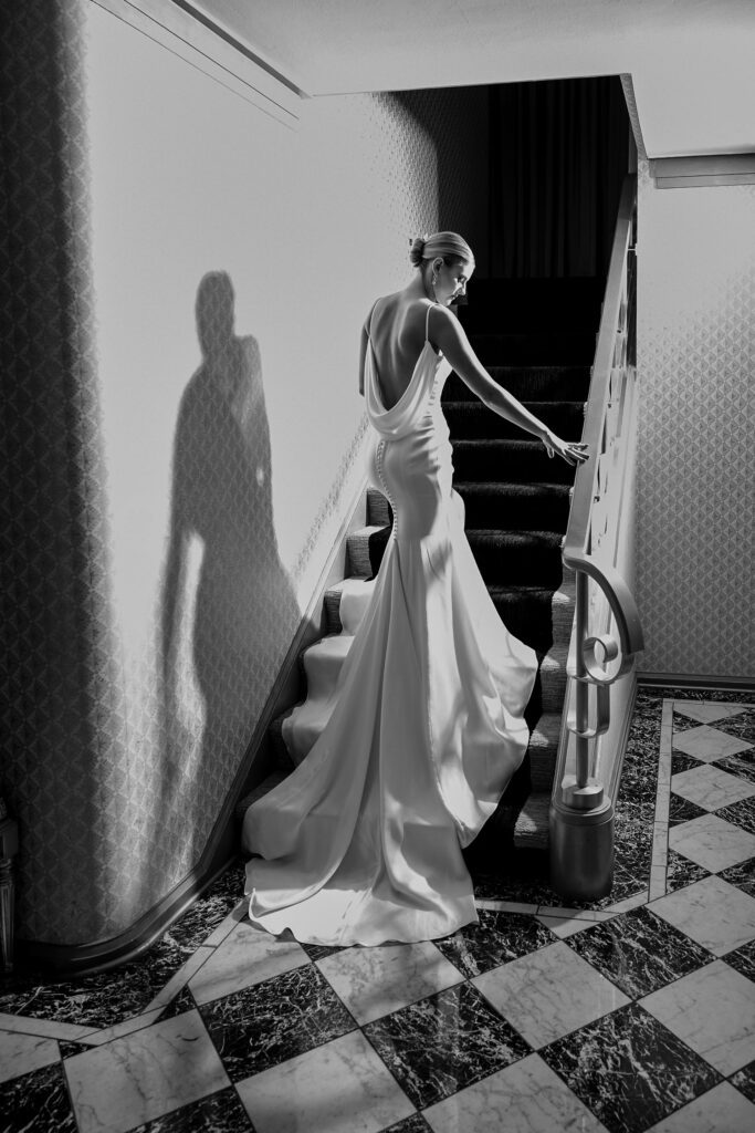 black and white bride walking up stairs in wedding gown