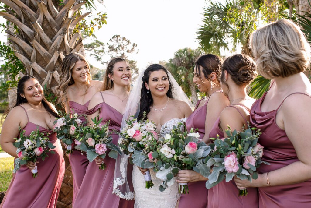 bride with bridesmaids in pink dresses with flowers