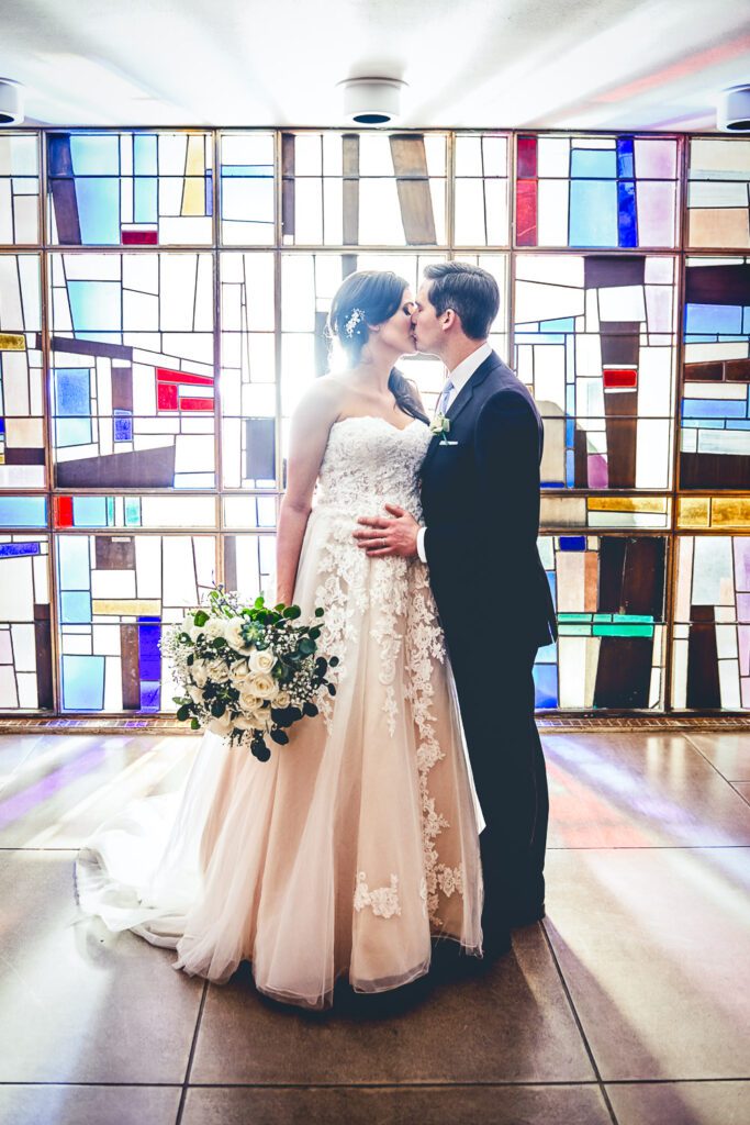 Stephens Chapel bride and groom kissing stained glass