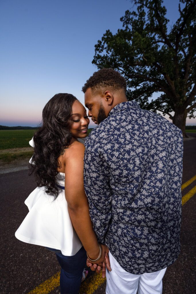 Tierre and Anthony, a black couple, hold hands and snuggle near big tree