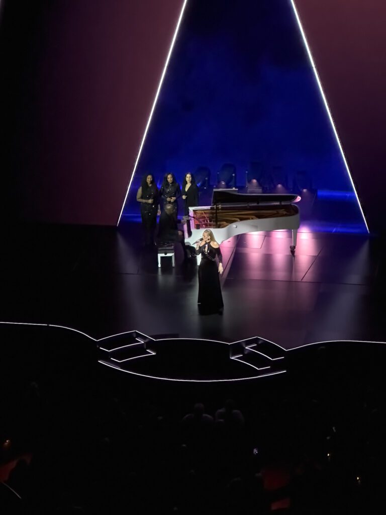 Adele on stage with white piano at Colosseum