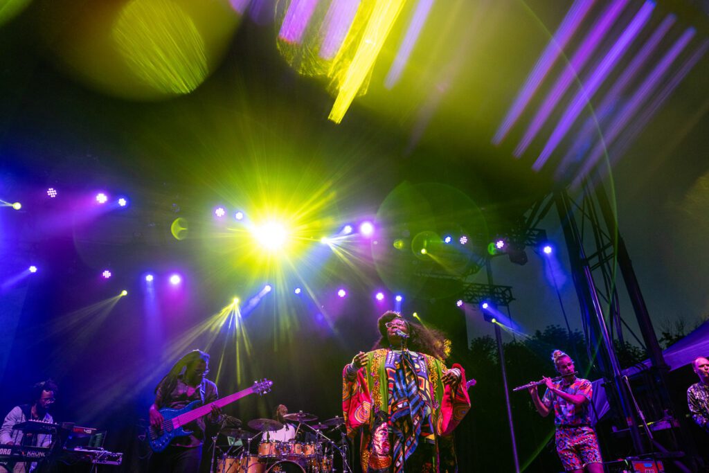 Tank and the Bangas under green and purple lights on stage.