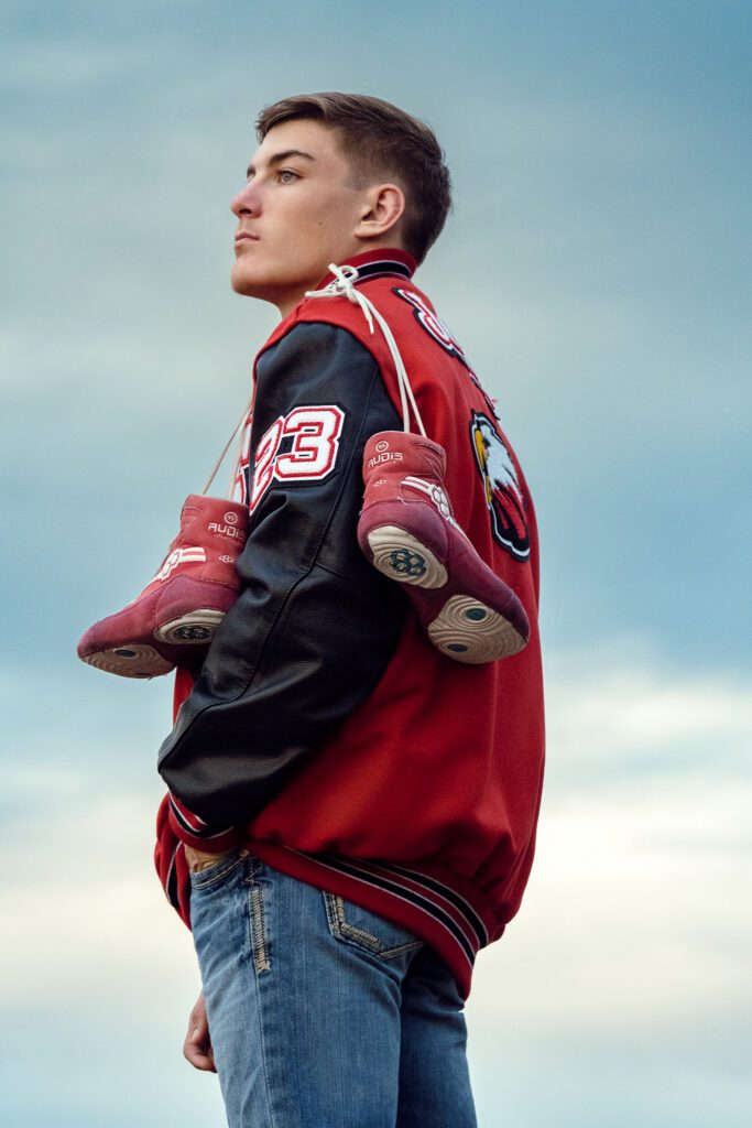 Ashland Missouri Senior wrestler wearing lettermans jackeet and shoes over his shoulders