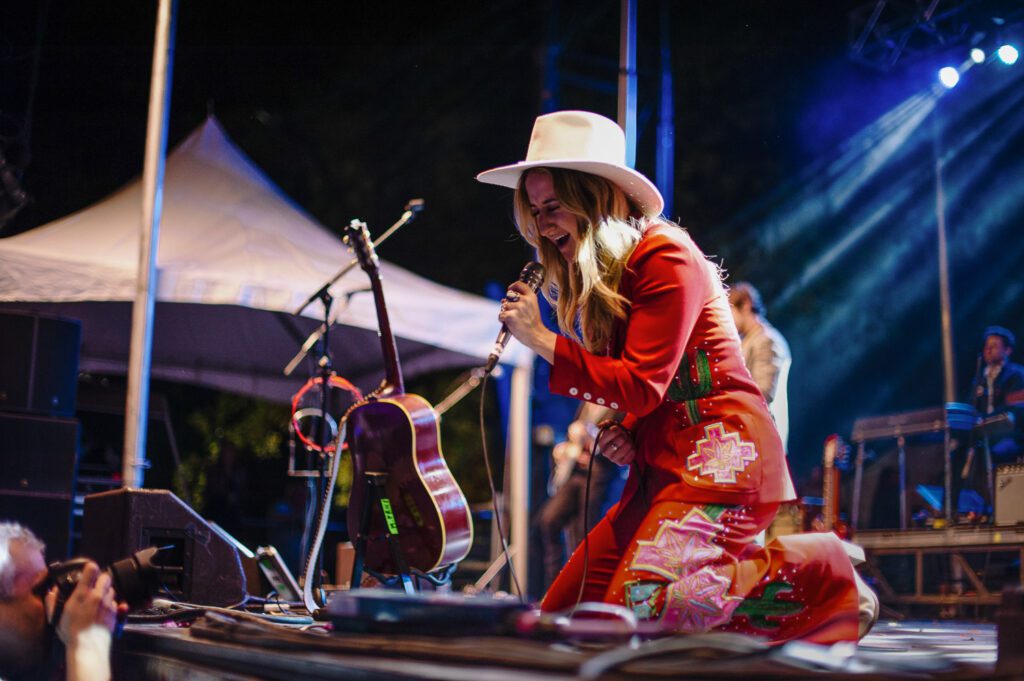 Margo Price wearing red Cowboy suit by Ashley Evans Western Wear.