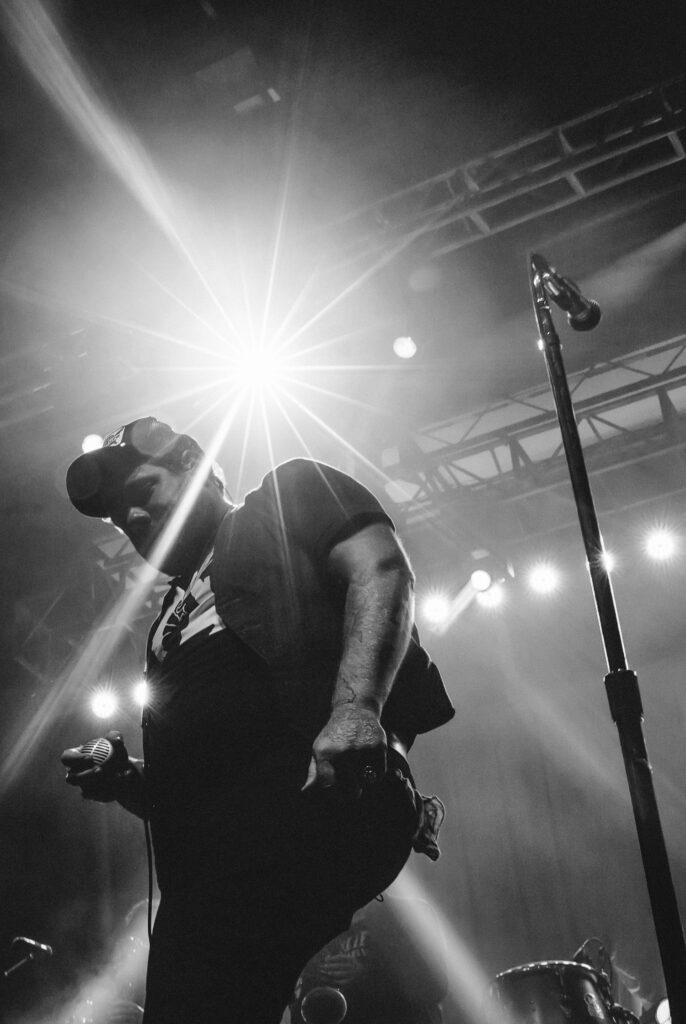 Nathaniel Rateliff under spot light near mic.