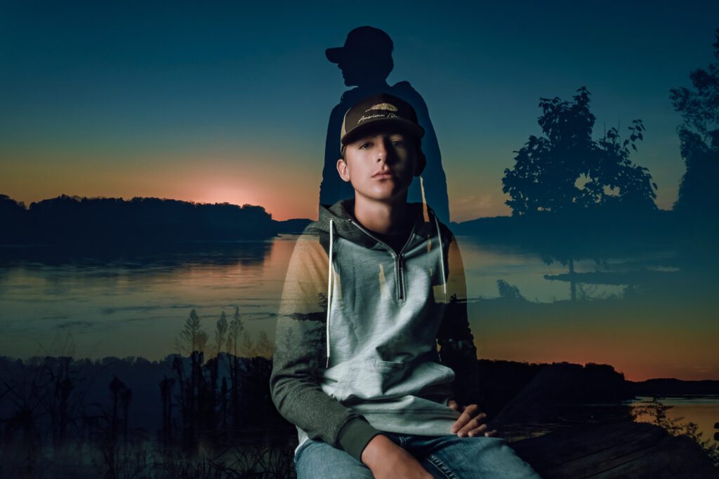 Double exposure of senior guy sitting on log and standing by missouri river
