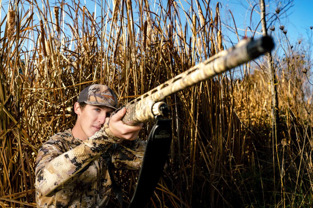 high school senior duck hunting with shot guy during senior photos