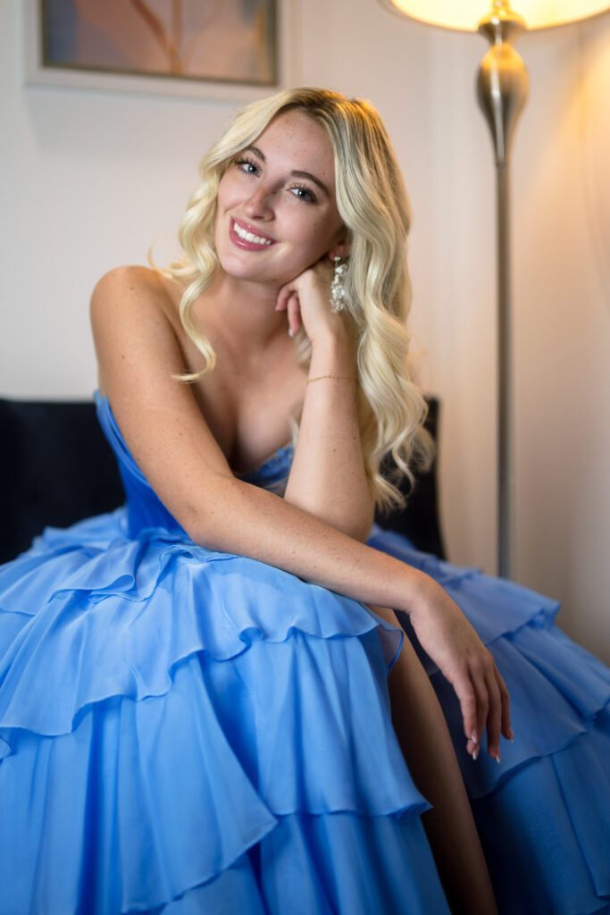 blonde senior girl in blue prom dress smiles