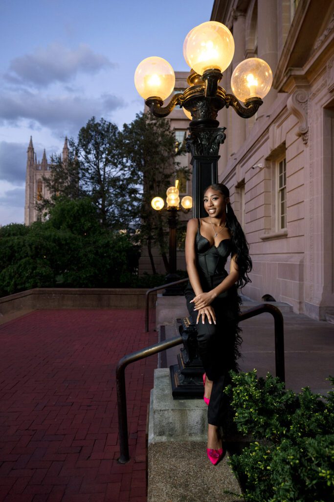 Black female model wearing black clothes leaning on light post on Mizzou Campus