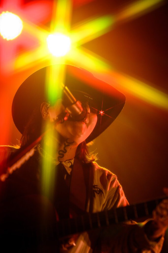 Elle King sings under yellow and orange lights