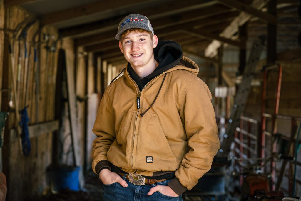 Montgomery County R-II high school senior wearing carhart jacket standing in old shed