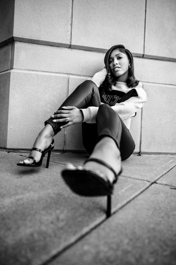 Black and white image of black college girl wearing high heels and mizzou sweatshirt.