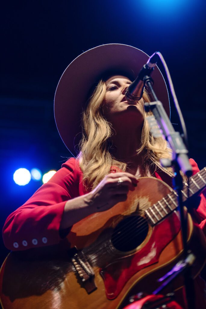 Margo Price singing while wearing red Cowboy suit by Ashley Evans Western Wear.