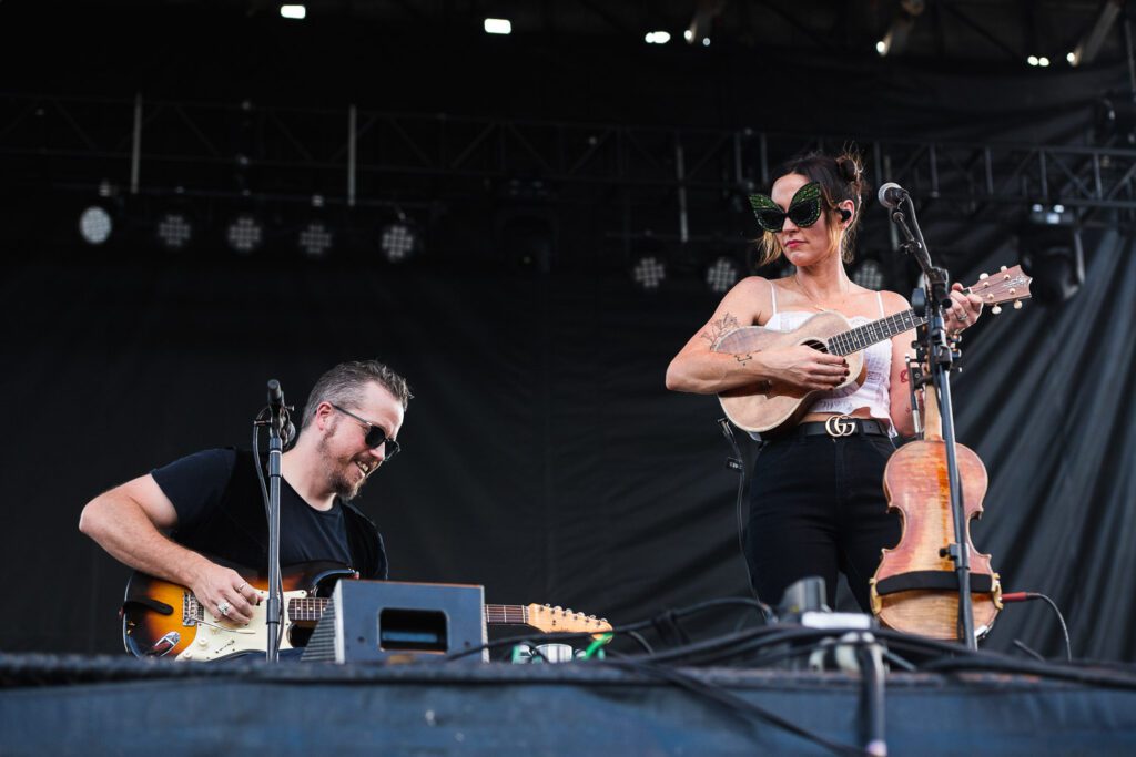 Amanda Shires and Jason Isbell playing on stage together at the Roots and Blues Festival.
