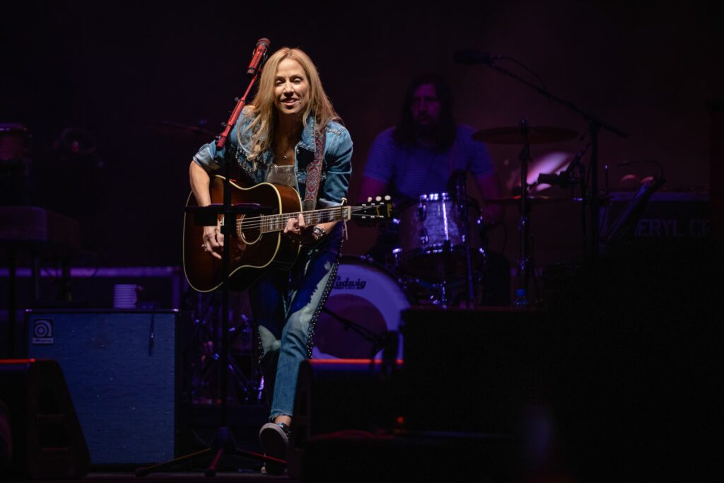 Sheryl Crow playing guitar on stage