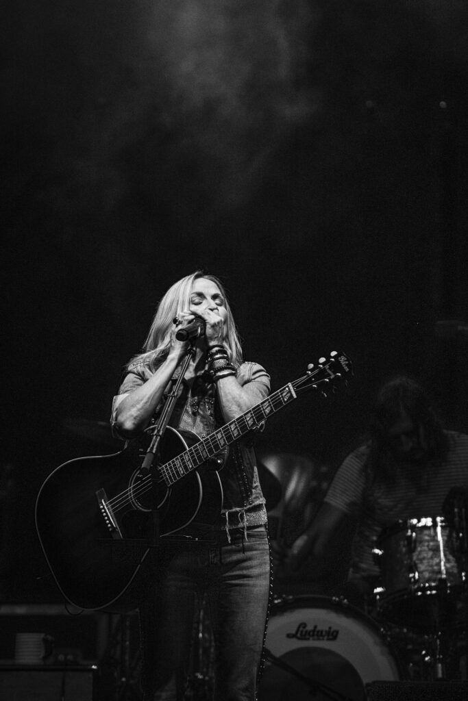 Sheryl Crow plays harmonica on stage