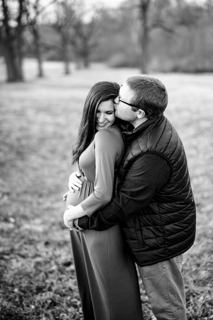 husband kisses pregnant wife during maternity shoot.