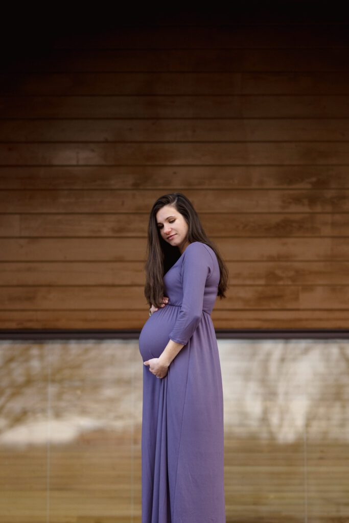 Mom to be wearing a purple maternity dress.