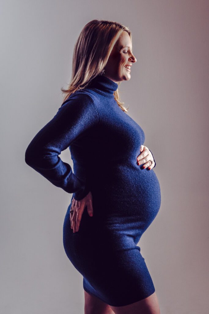 pregnant woman smiling holding stomach