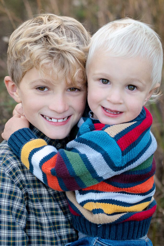 brothers hugging in field in sweaters in Columbia, MO