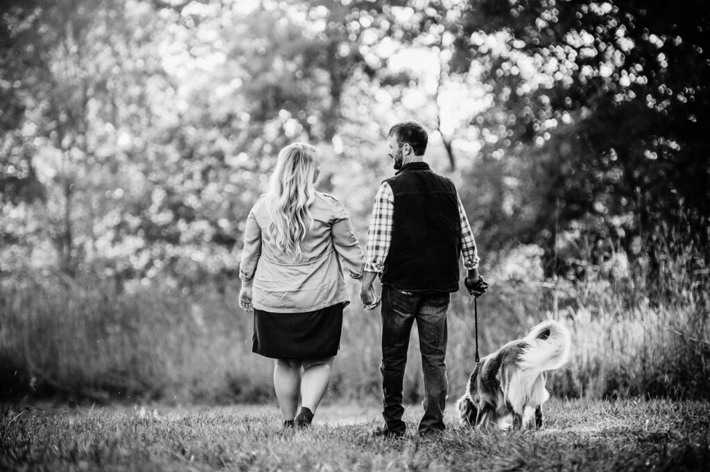 couple walking dog holding hands