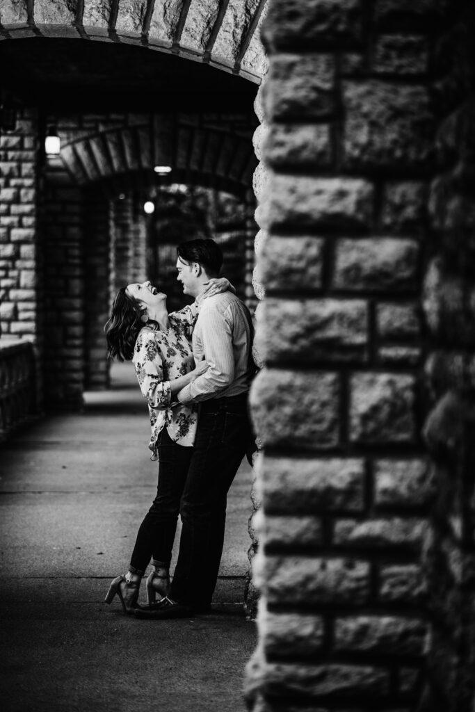 girl laughing while leaning against wall with fiance